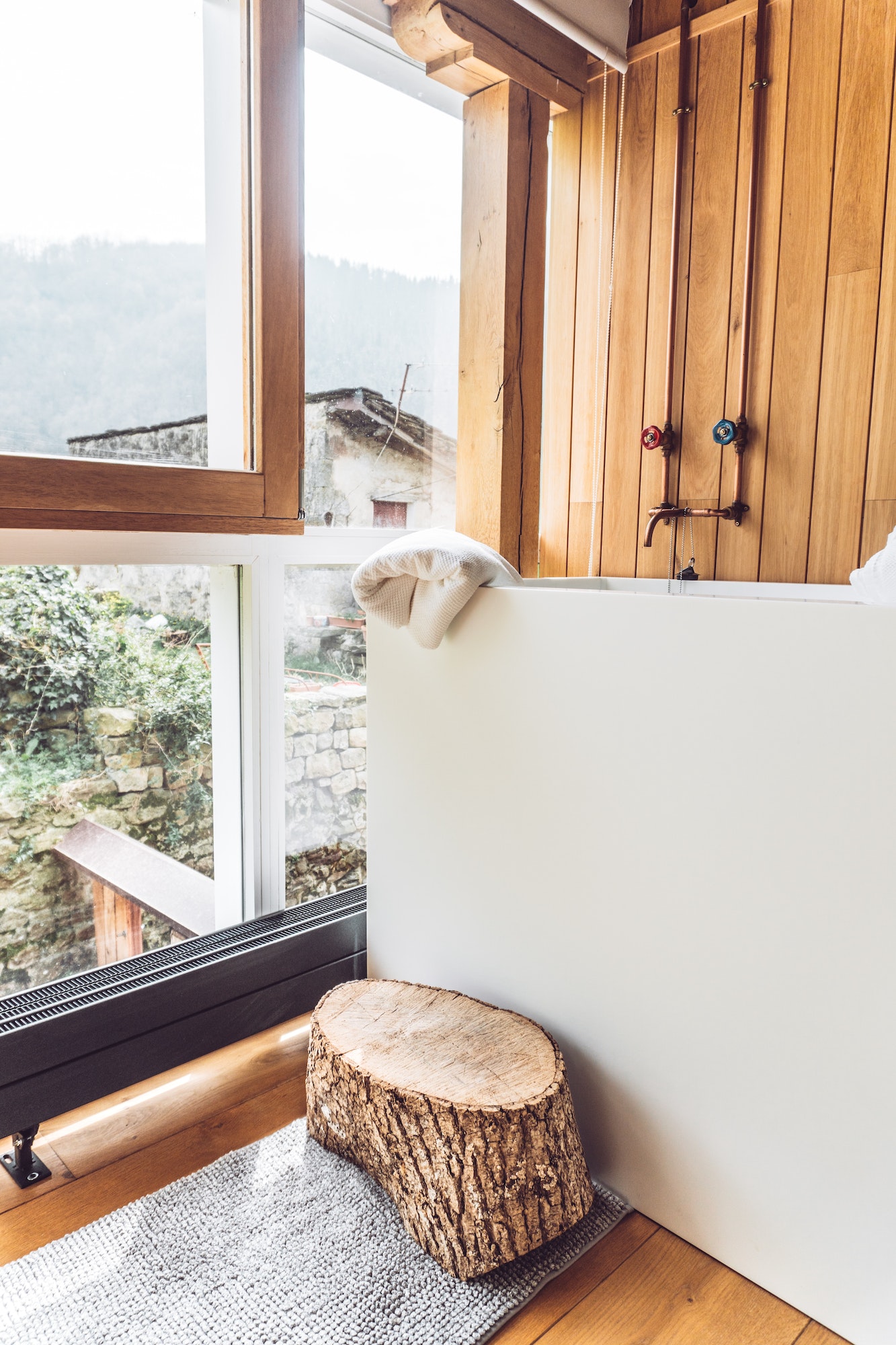 stylish country hotel room with window overlooking the garden and the mountains furnished with wood